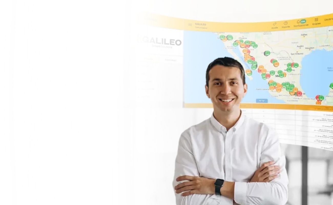 Líder de operaciones de negocios sonriendo, frente a un dashboard de geolocalización y datos de Galileo Smart Solutions, que representa la gestión basada en evidencia.