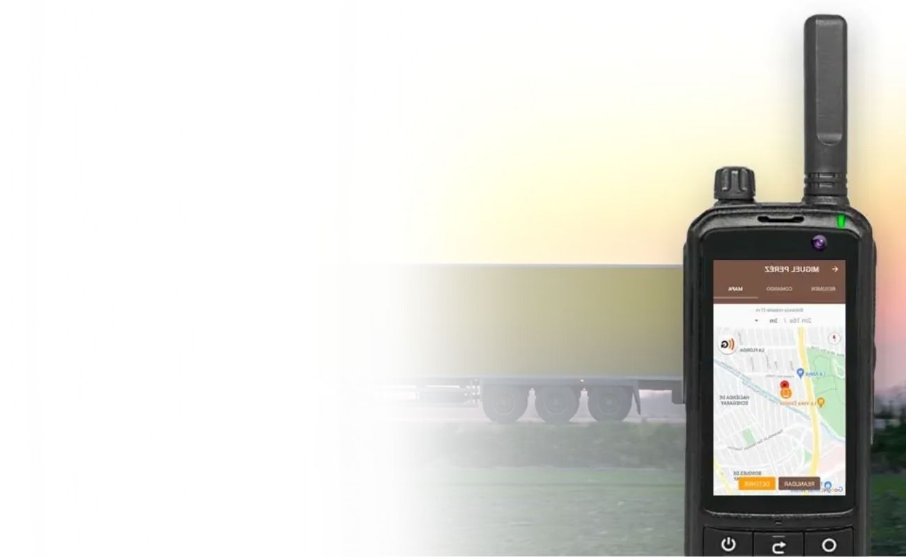 Un radio de uso rudo mostrando un mapa de rastreo GPS, con un camión de transporte de carga en la carretera durante el atardecer.