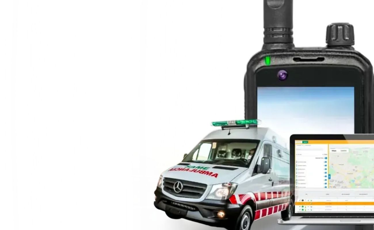 Hombre en un centro de control, usando un radio de uso rudo para comunicarse, mientras monitorea la geolocalización de ambulancias en una pantalla.