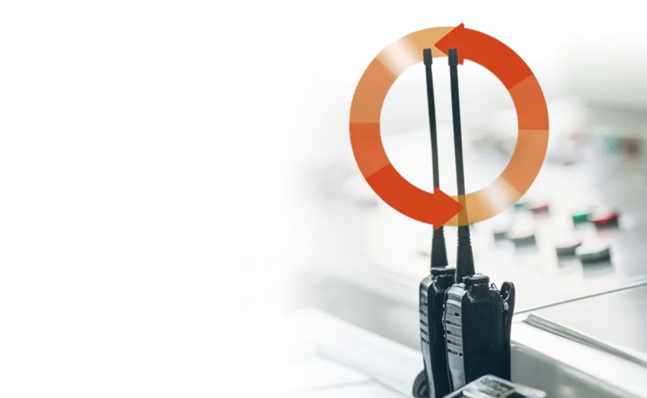 Un par de radios antiguos con antenas, simbolizando las frecuencias UHF y VHF, con un icono de ciclo de renovación, en un fondo de centro de control.