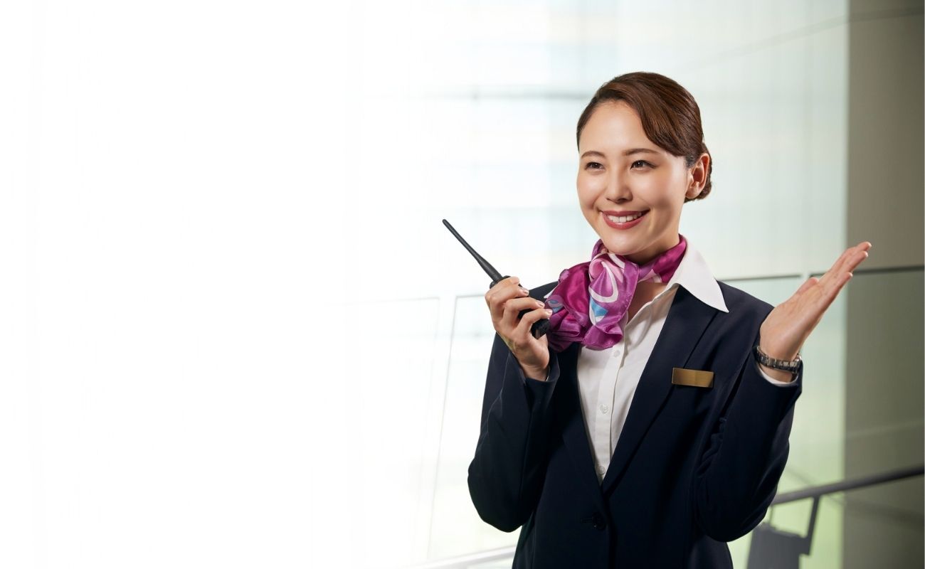 Colaboradora de hospitalidad utilizando un radio PoC con plataforma Zello Work para coordinación de servicios.