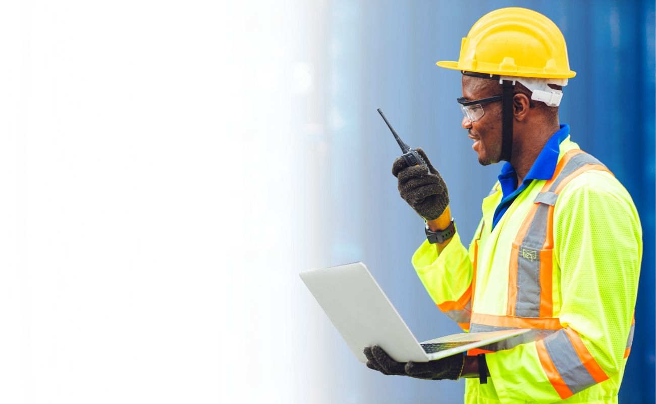 Operador logístico utilizando un radio PoC con inteligencia artificial y conexión satelital en un centro de distribución.