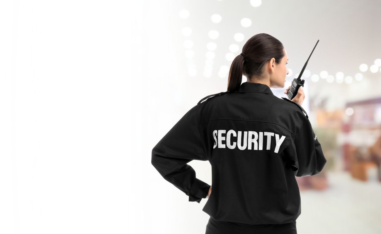 Oficial de seguridad en una tienda departamental utilizando un radio PoC con inteligencia artificial para coordinación inmediata.